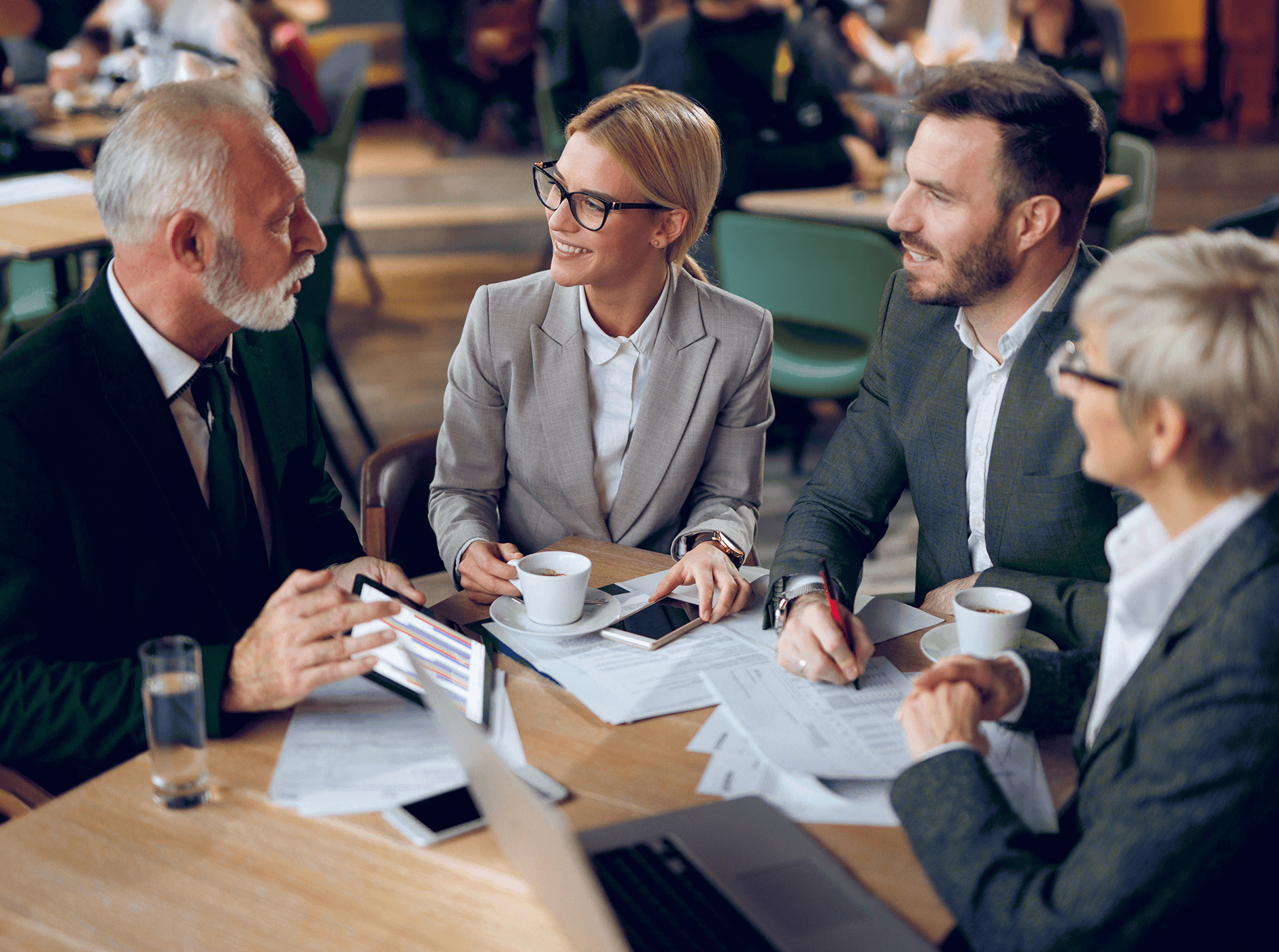 diverse age group of men and women in a casual meeting drinking coffee